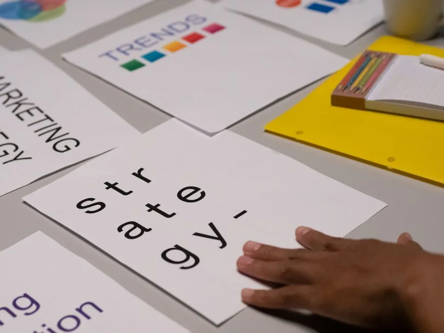 Gros plan détaillé d’une main montrant des graphiques colorés avec un stylo bleu sur une surface en bois.